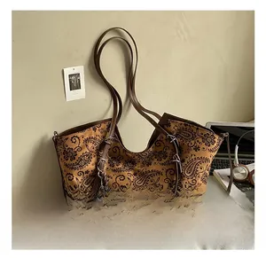 Close-up of vintage brown paisley tote bag with leather straps and bear charm