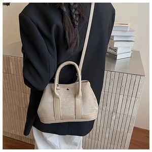 Detailed view of apricot vintage suede tote bag with metal snap button and handle