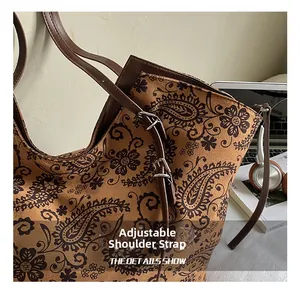 Detail showing the adjustable brown leather strap of a vintage paisley print tote bag