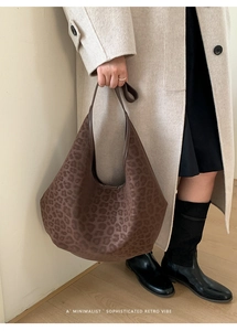 Detail of vintage leopard print tote bag with soft suede texture on a stylish model