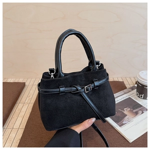 Detail of a black frosted faux suede bucket bag with metal buckle and round handle