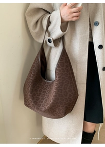 Detail shot of vintage leopard print hobo bag worn with a classic beige wool coat