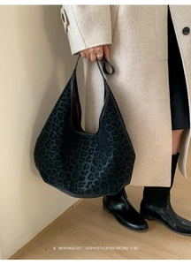 Detailed close-up of dark leopard print hobo bag with textured flocking material