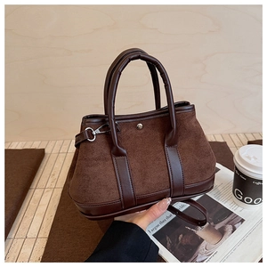 Detail of dark brown tote bag with suede texture and adjustable shoulder strap