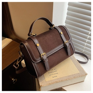 Detail of vintage square bag with contrast suede textures and golden hardware