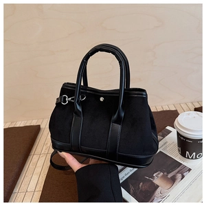 Detail of the black suede and leather patchwork tote bag with adjustable shoulder strap