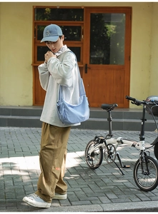Scatto all'aperto di una borsa hobo azzurra capiente indossata a tracolla per uso quotidiano