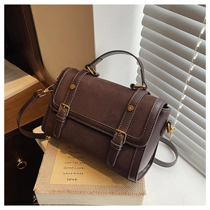 Detail view of vintage brown crossbody bag with textured leather stitching and gold buckle