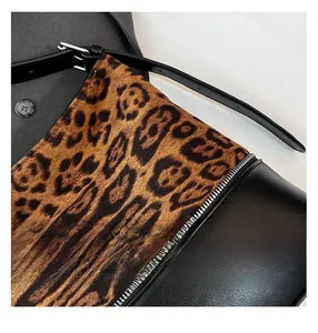 Close-up of leopard print suede and black leather stitching with silver zipper detail