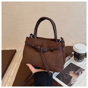 Close-up of vintage brown suede bucket bag with leather strap and silver metal buckle