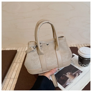 Detail of beige suede crossbody bag with smooth PU handles and adjustable strap