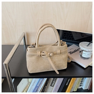 Detail of matte suede texture and knotted strap on khaki crossbody bucket bag