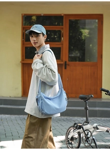Dettaglio di una borsa a tracolla celeste dal design urbano e stile casual chic