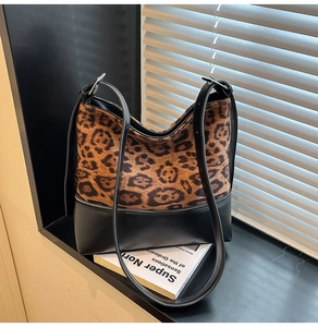 Close-up of leopard print suede and black leather shoulder bag with zipper detail