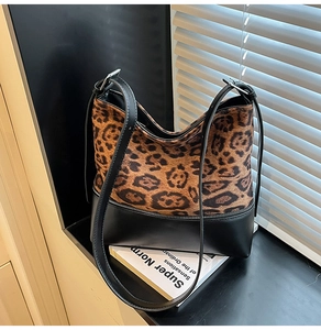 Detail of leopard print faux fur and black leather stitching on a bucket bag