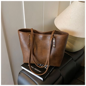 Close-up of vintage brown tote bag texture and embossed logo on black books
