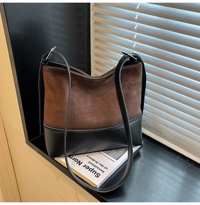 Detail of suede and leather patchwork bag with silver zipper and adjustable straps
