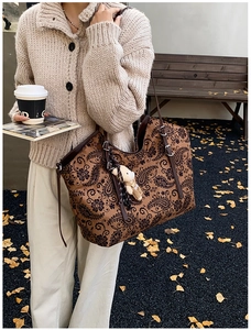 Detail of vintage paisley tote bag with dark brown strap and cute bear charm pendant