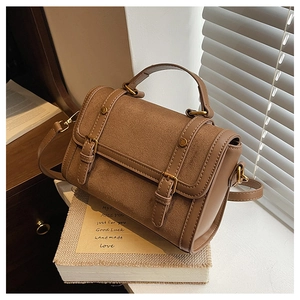 Detail of vintage crossbody bag with suede texture, leather trim and gold metal buckles