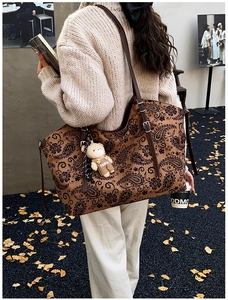 Detail of vintage paisley tote bag with brown faux suede texture and cute bear charm