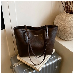 Close-up of a large coffee brown tote bag with leather texture and gold HOCOMU logo