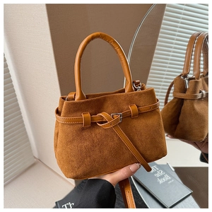 Detail view of retro brown frosted suede handbag with silver metal buckle and strap handle