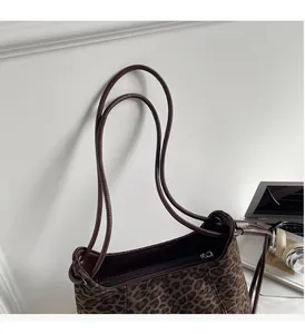 Detailed close-up of leopard print shoulder bag with brown straps and silver zipper