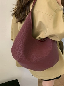 Chic burgundy leopard print hobo bag worn by model, large capacity tote for daily commute