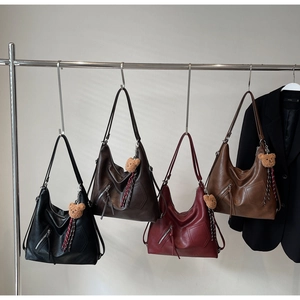 Detail view of large hobo bags in four colors with bear charms and zipper pockets