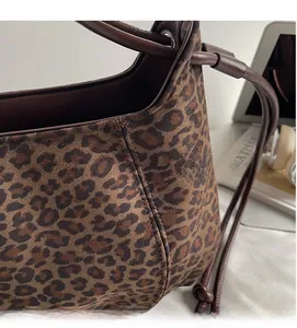 Close-up of leopard print shoulder bag featuring soft suede texture and leather strap