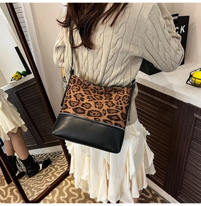 Close-up of leopard print pony hair and black leather patchwork crossbody bucket bag