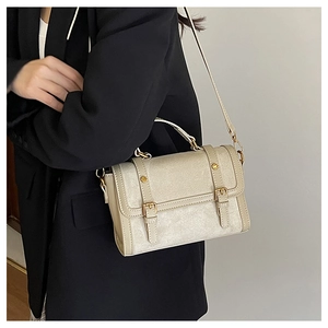 Detail of vintage beige crossbody bag with textured leather and gold buckle accents