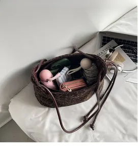 Spacious interior of leopard print tote bag holding umbrella, wallet and pouches