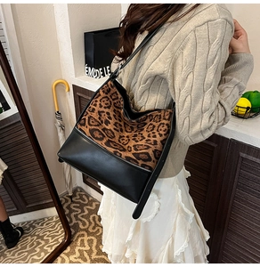Fashionable leopard print and black leather tote bag worn by a model in a retro setting