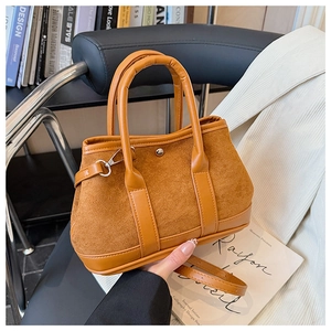Detail of brown suede and smooth leather stitching on a vintage bucket handbag