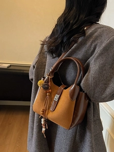 Vintage brown frosted bucket bag with colorful tassel charm shown on a fashion model