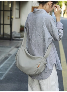 Borsa a tracolla in nylon grigio-verde con tracolla larga ed etichetta decorativa arancione