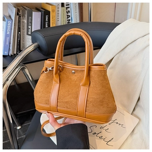 Detail of vintage brown suede leather tote showing contrast textures and metal buckle