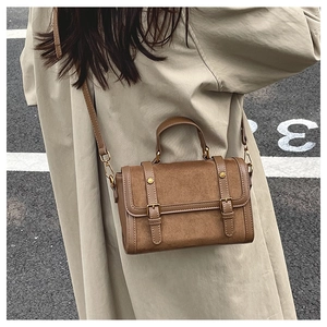 Detail of vintage brown patchwork handbag with dual buckle straps and gold studs