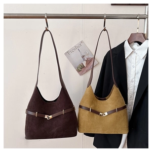 Detail of vintage suede tote bags with metal buckles hanging in a lifestyle fashion setting