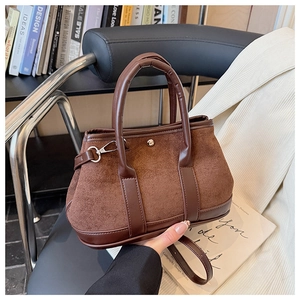 Detail of vintage brown suede tote bag with silver buckle and smooth leather handles