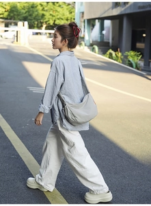 Foto di strada di una modella che indossa una borsa a tracolla grigio chiaro minimal
