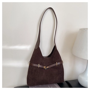 Detailed close-up of dark brown suede tote bag with decorative leather strap and gold buckle