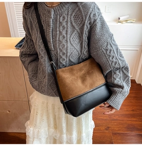 Detail of faux suede patchwork shoulder bag with silver zipper and leather strap