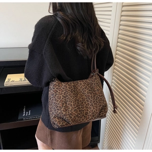 Detail view of leopard print shoulder bag with brown leather strap and drawstring decor