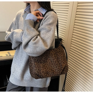 Leopard print shoulder bag worn over a grey knit sweater for a vintage casual look