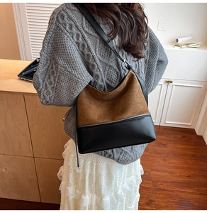 Detail showing the brown suede and black leather contrast on this stylish bucket bag