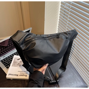 Close-up of black matte waterproof crossbody bag with wide strap in an office setting