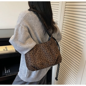 Detail of a brown leopard print shoulder bag worn with a stylish grey knit sweater
