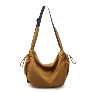 Dettaglio borsa a mezzaluna in nylon camel con tracolla ed etichetta arancione